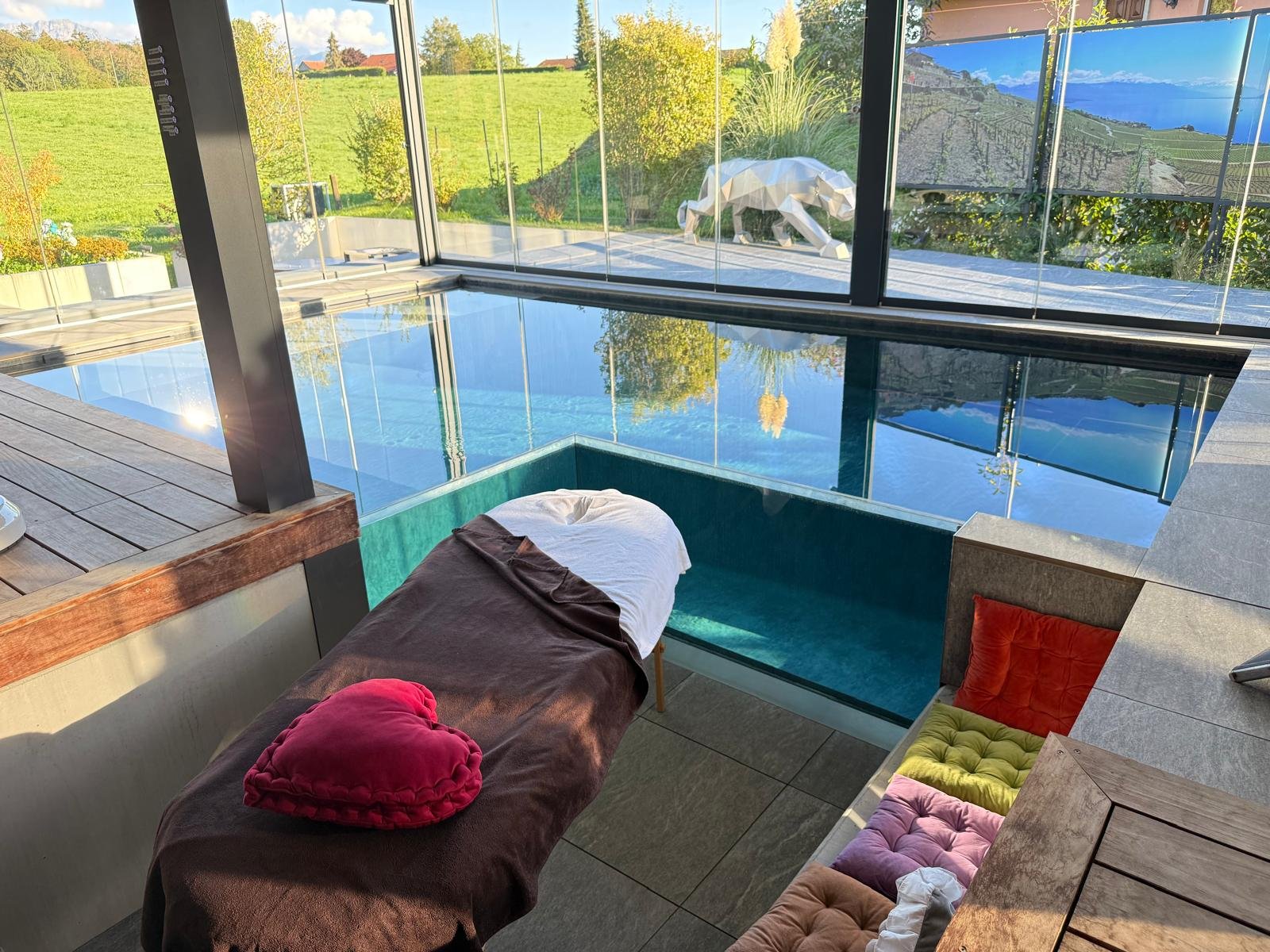 Table de massage dressée au bord du bassin de Secret Paradise, face aux vignes du Lavaux et au lac Léman